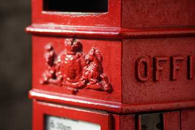 A close-up of a red post box